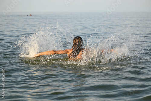 Spray with water. Girl having fun bathing in the sea.