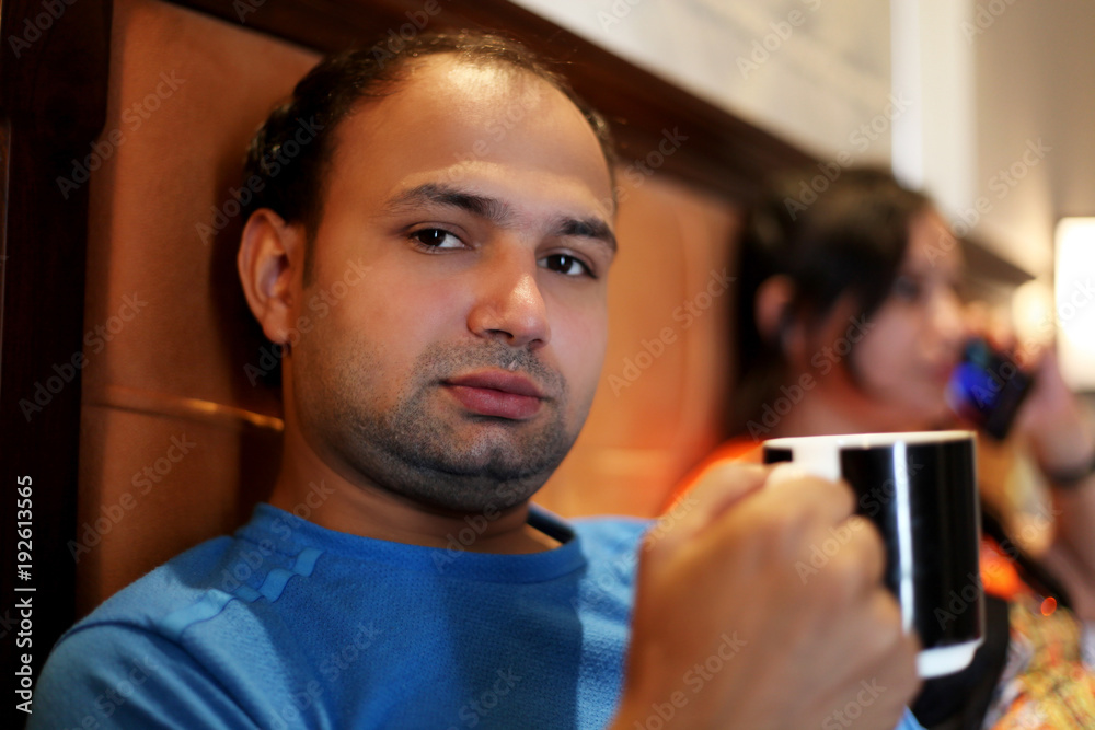 Young men of Indian ethnicity sitting on the bed in hotel room