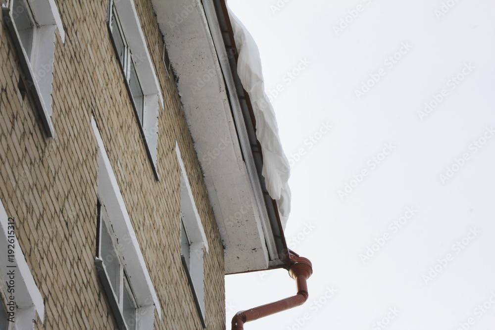 Dangerous snow falls hanging down from the roof Dangerous snow falls hanging down from the roof