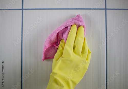 Housewife work, a housewife carries out her job, is clean with a cloth in her hand, and gloves on her hands, rubber gloves for cleaning