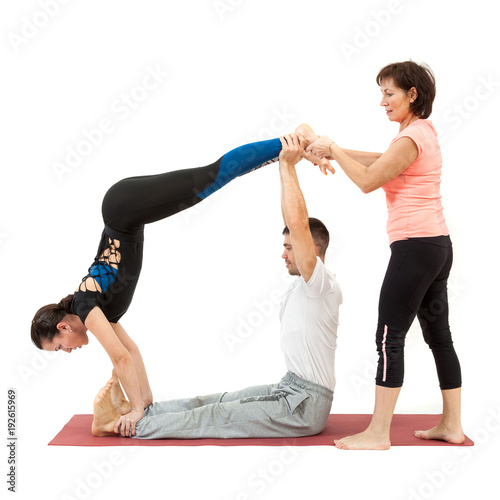 man and woman doing yoga under the guidance of a trainer photo