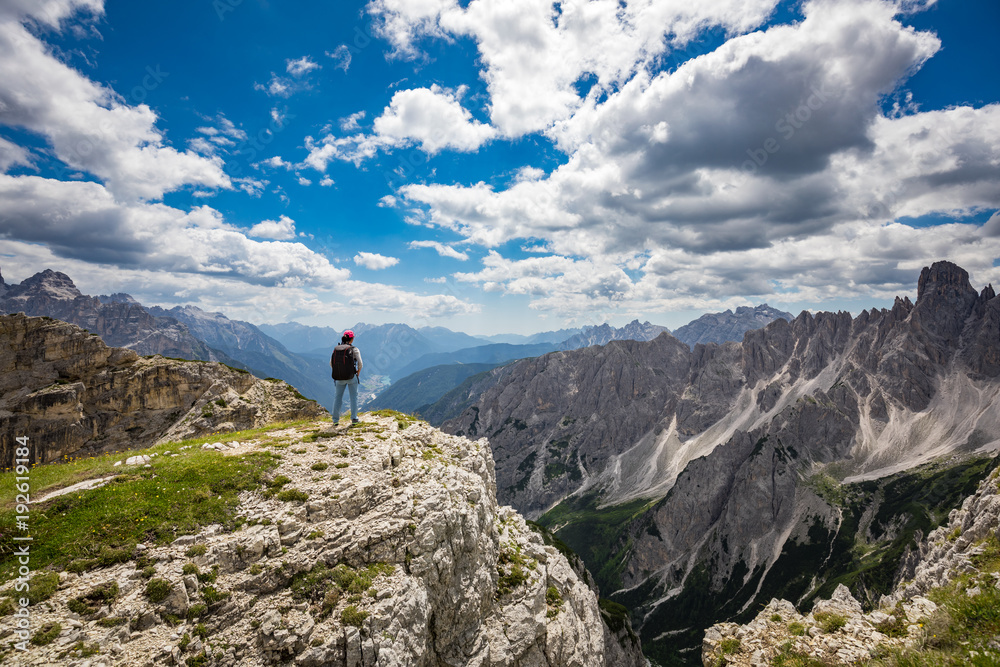 Hiker woman standing up achieving the top Dolomites Alps.