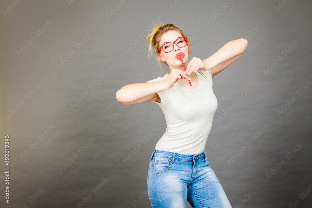 Happy woman holding fake lips on stick Happy woman holding fake lips on stick