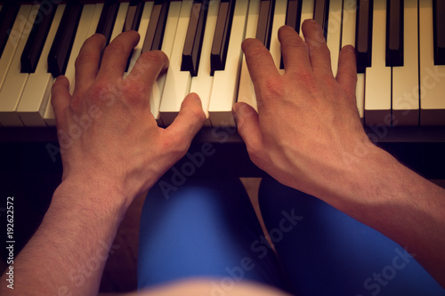 men's hands playing the piano