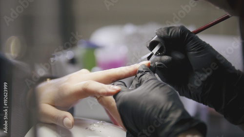 Small business - manicurist - nail master in medical mask doing professional manicure