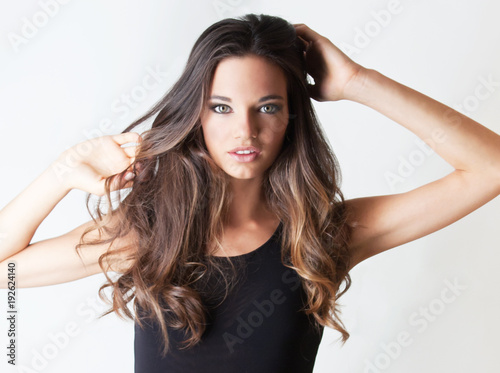 Giovane ragazza con occhi chiari e capelli mossi, isolata, sguardo affascinante