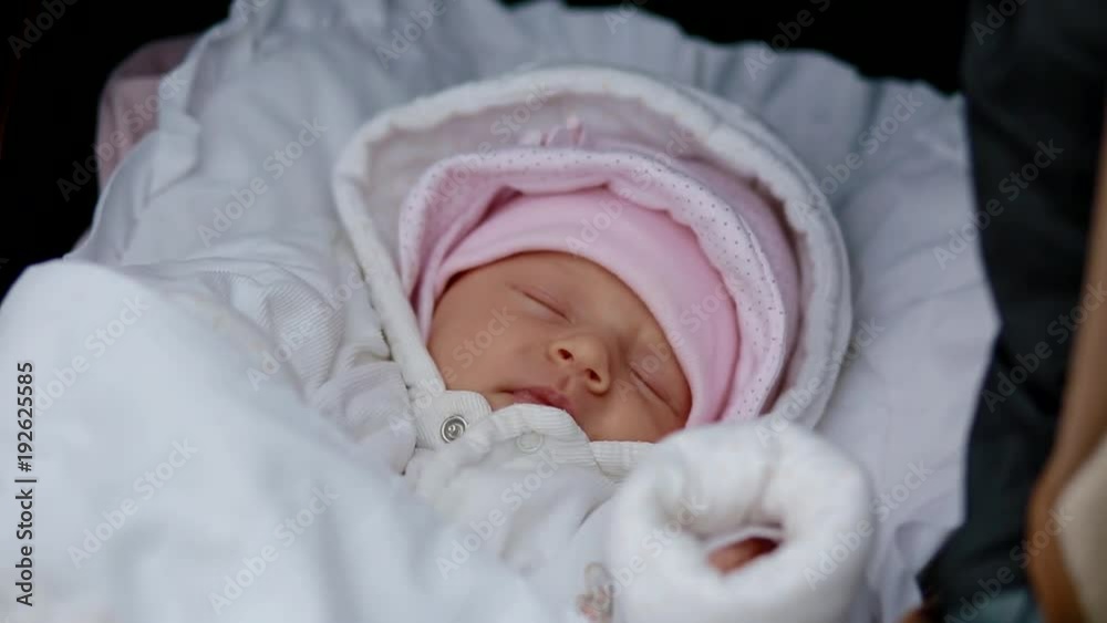 Mother touching the face of her newborn daughter. Cute child in baby carriage. Mother touching the face of her newborn daughter. Cute child in baby carriage.