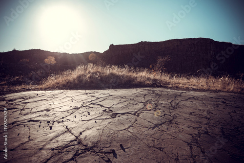 The concept of global warming is a cracked scorched earth soil drought desert landscape dramatic sunset.
