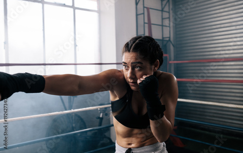 Female boxer training inside a boxing ring © Jacob Lund