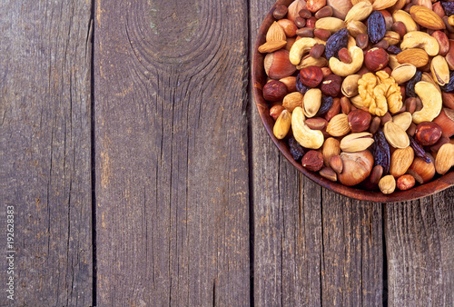 mix nuts on wood plate on wood background