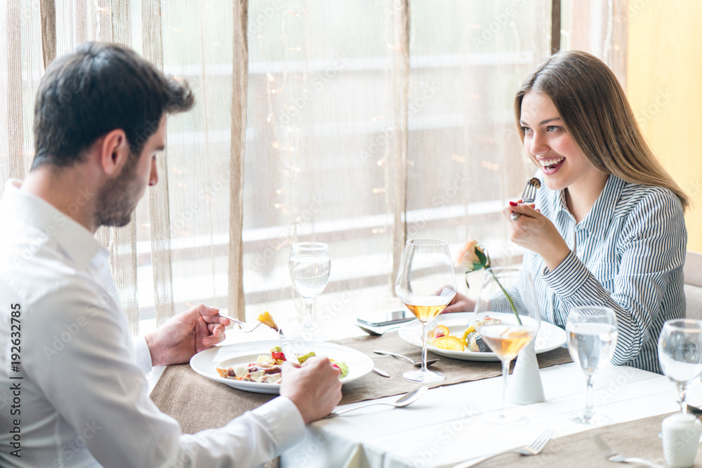 food, christmas, holidays and people concept - smiling couple eating main course at restaurant food, christmas, holidays and people concept - smiling couple eating main course at restaurant