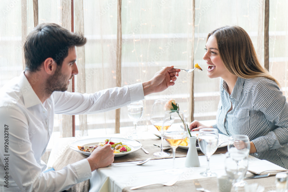 food, christmas, holidays and people concept - smiling couple eating main course at restaurant food, christmas, holidays and people concept - smiling couple eating main course at restaurant