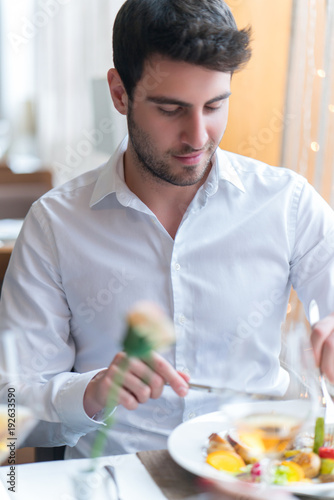 Young man eating a healthy food at restaurant