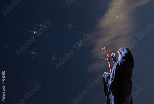 eine mysteriöse Frau betrachtet in der Nacht ein Sternbild photo