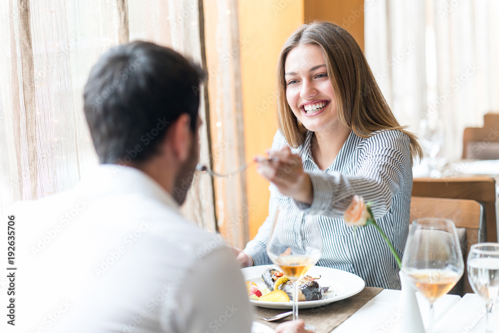 food, christmas, holidays and people concept - smiling couple eating main course at restaurant