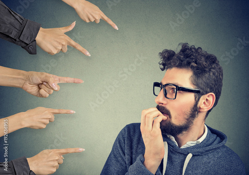 Valokuva Anxious man judged by different hands