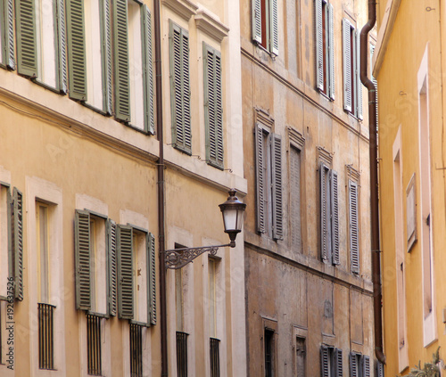 Building in Rome  details of old facade  wall with windows and wooden shutters.