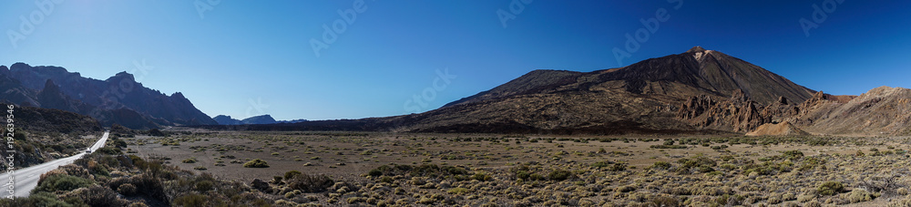 Kraterebene mit Felsformation Roques de García und Vulkan Teide auf der Insel Teneriffa als Panoramabild mit Bergstraße