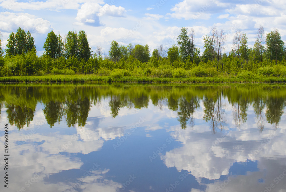 Beautiful summer landscape with reflection of clouds in the river