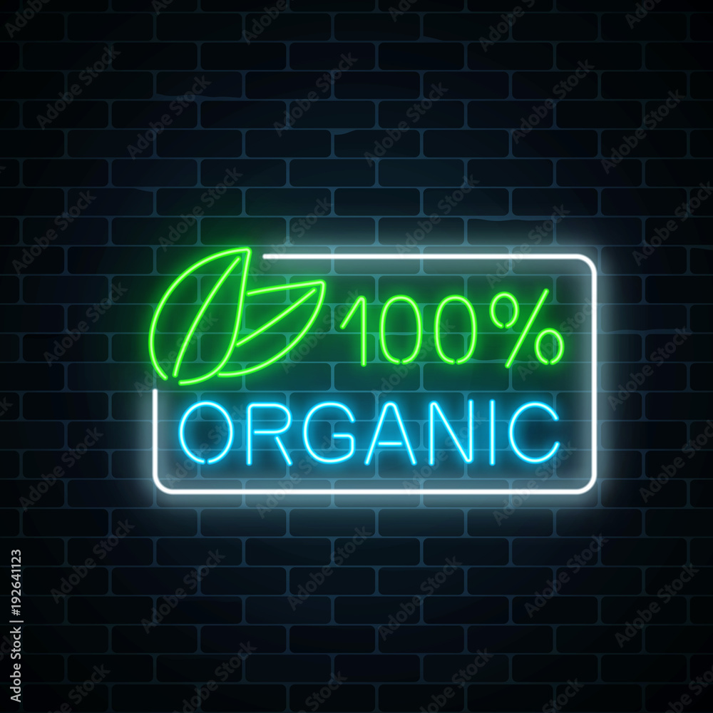 Fototapeta premium Neon 100 percent organic production sign on dark brick wall background. Natural cosmetics glowing advertising symbol.