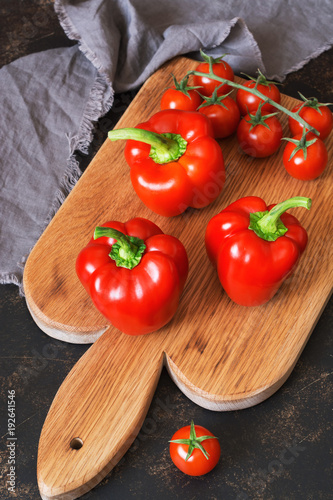 Sweet red pepper with cherry tomatoes on a cutting board. selective focus.