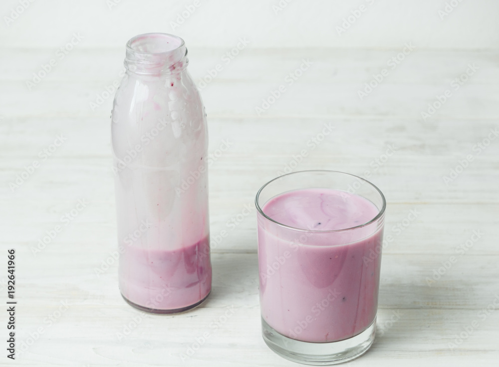 Yogurt in a glass and a bottle on a white background. Yogurt in a glass and a bottle on a white background.