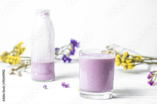 Yogurt in a glass and a bottle on a white background.