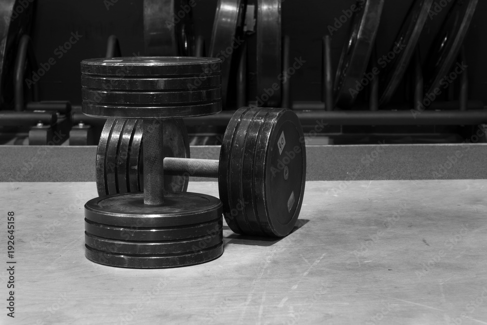 Used and old black gym dumbbells, black and white image, photo. Used and old black gym dumbbells, black and white image, photo.
