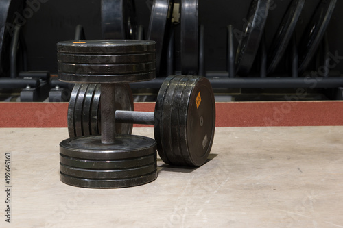 Two old and used gym black metal dumbbells. © Domagoj