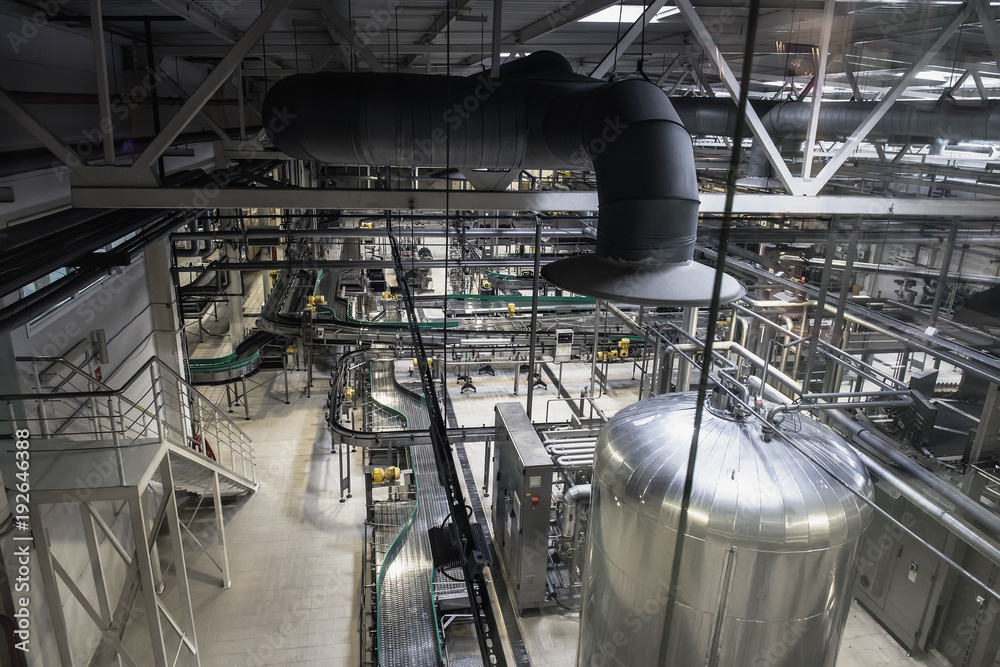 Brewing production, workshop with steel tanks, pipes and machinery at modern beer factory