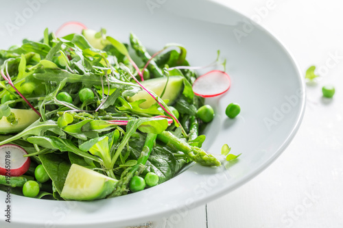 Closeup of green salad with spinach, radishes and asparagus