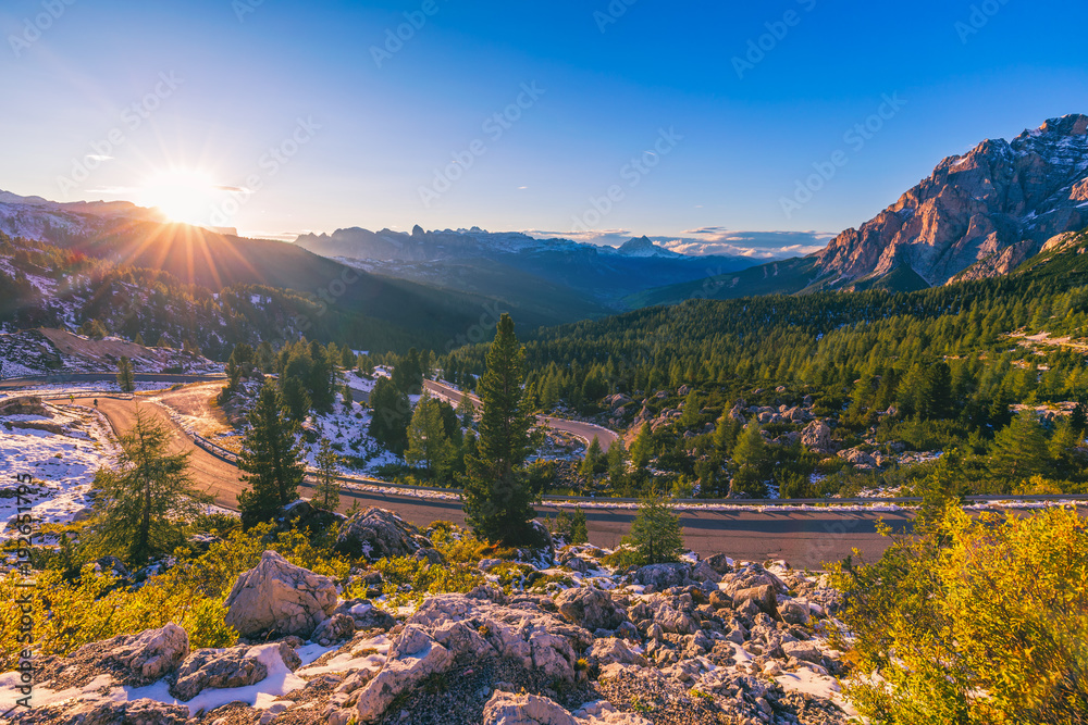 Dolomite Alps in Italy. Beautiful day. The road passes in the coniferous forests at the foot of limestone and dolomite rocks. The concept of active and car tourism