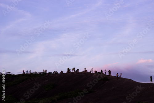 Fototapeta Naklejka Na Ścianę i Meble -  silhouette of people on top of hill two brother in rio de janeiro with sky in purple color