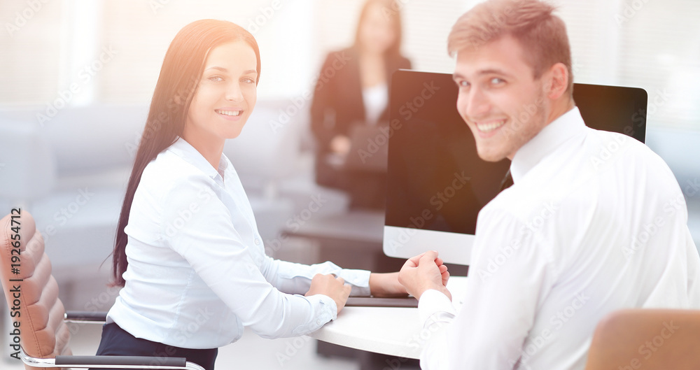 members of the business team sitting at Desk and looking at came members of the business team sitting at Desk and looking at came