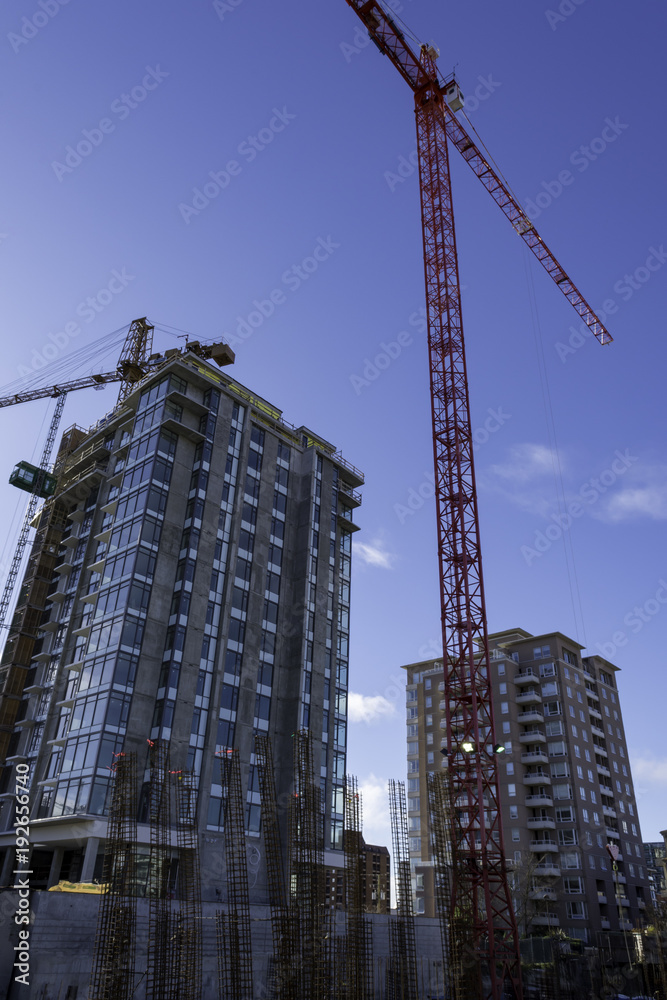 Construction cranes on job site shot looking up