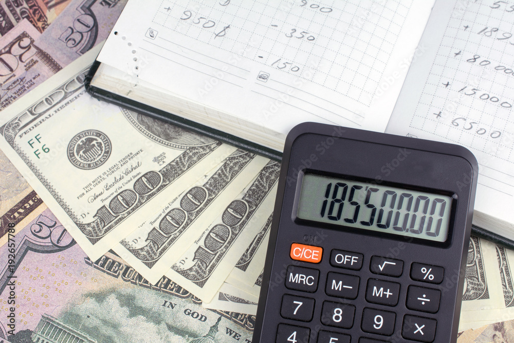 calculator green notebook with dollar bills on the background of money borrowed money concept calculator green notebook with dollar bills on the background of money borrowed money concept