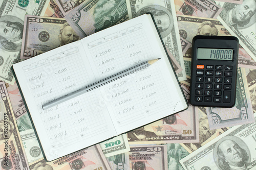 Money made on the stock exchange, dollars, green notepad, calculator, gray pencil