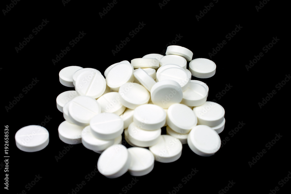 white round tablets painkiller copy space, black background, selective focus