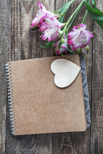 notebook with heart on wooden background
