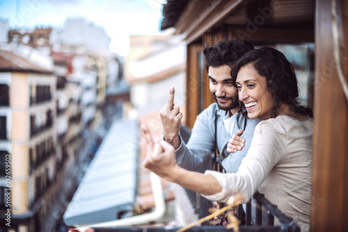 Young couple giving the middle finger at window