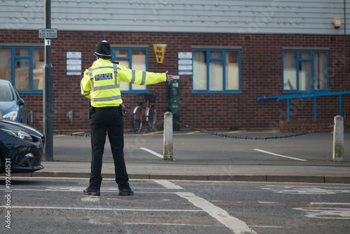 policeman directing tradffic on busy road in UK
