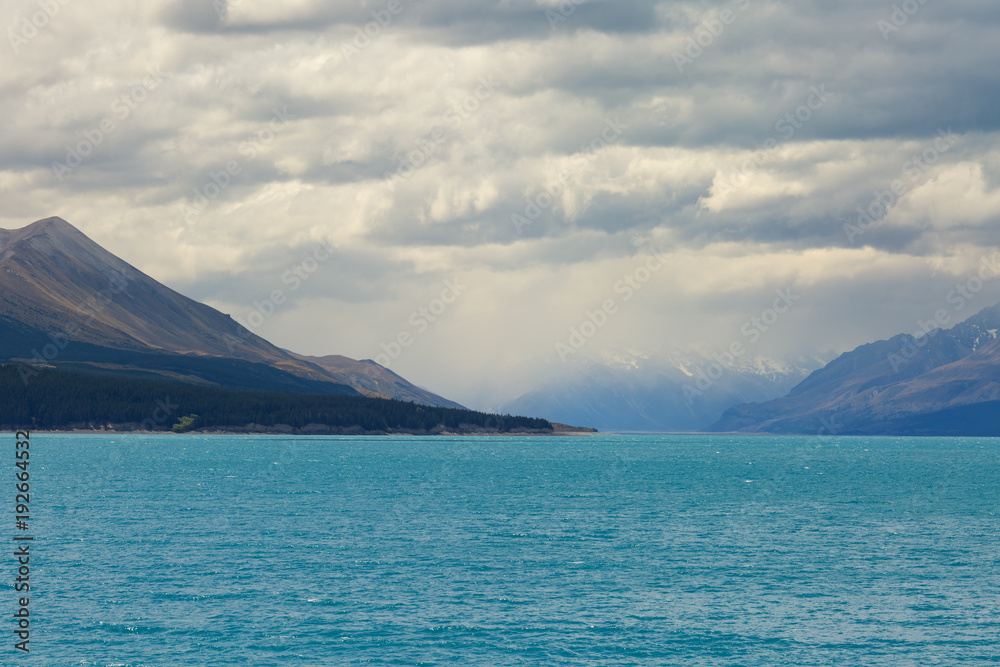 Mountains with heavy clouds and lake Pukaki on the foreground, New Zealand, South island, Canterbury