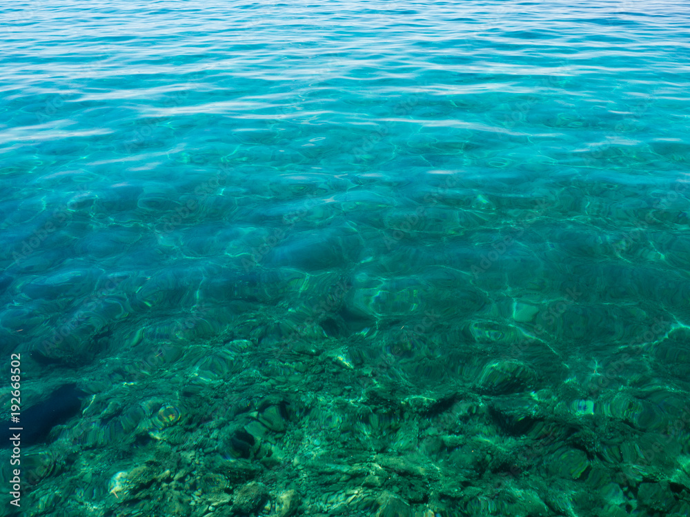 Turquoise transparent water off the coast of the Mediterranean Sea on a sunny summer day