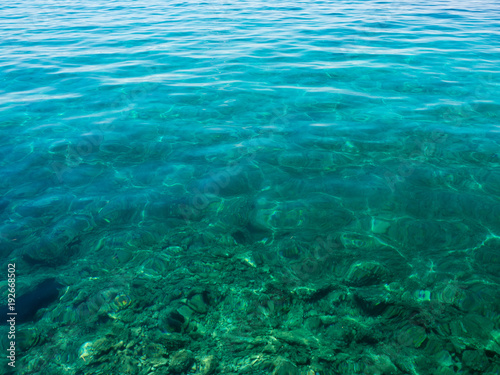 Turquoise transparent water off the coast of the Mediterranean Sea on a sunny summer day