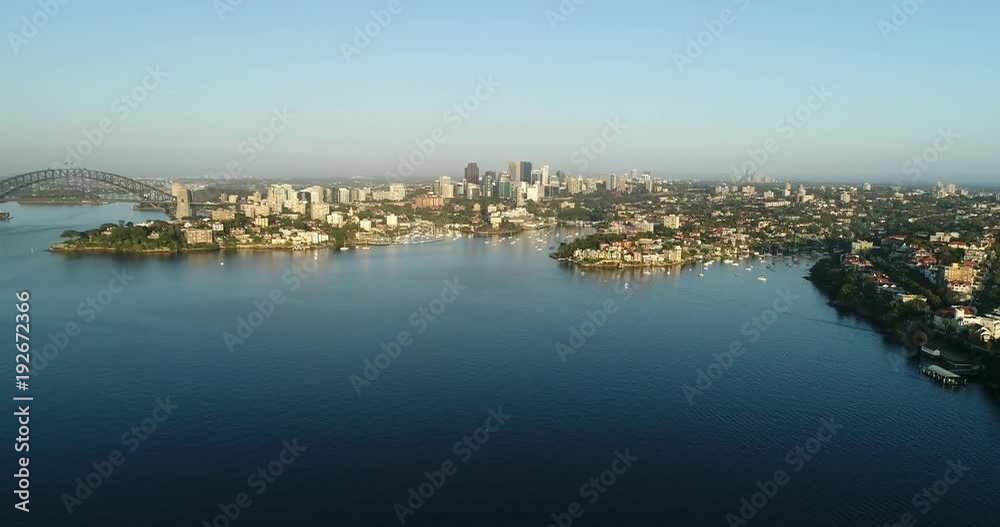 Above the water aerial rotation over Sydney Harbour from Lower North shore wealthy suburbs of Mosman, Cremorne to North Sydney, Kirribilli and Sydney Harbour bridge, Cirular quay, CBD and domain.
