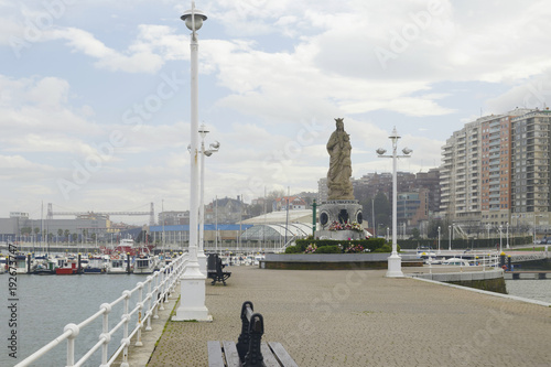 Blessed Virgin Mary statue in the fishing port of Santurtzi, Basque Country, Spain. Outdoors on a cloudy day. No people. photo