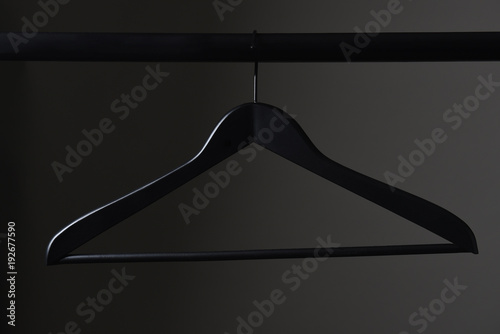 A black coat hanger and closet rod photo