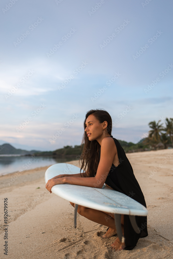 sun-tanned brunette attractive girl or woman (tourist, surfer)