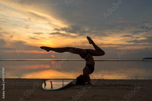 young flexible fit woman or girl posing on sandy beach