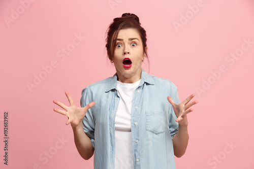 Beautiful woman looking suprised isolated on pink